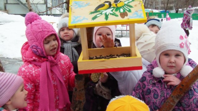Дети кормят птих на прогулке